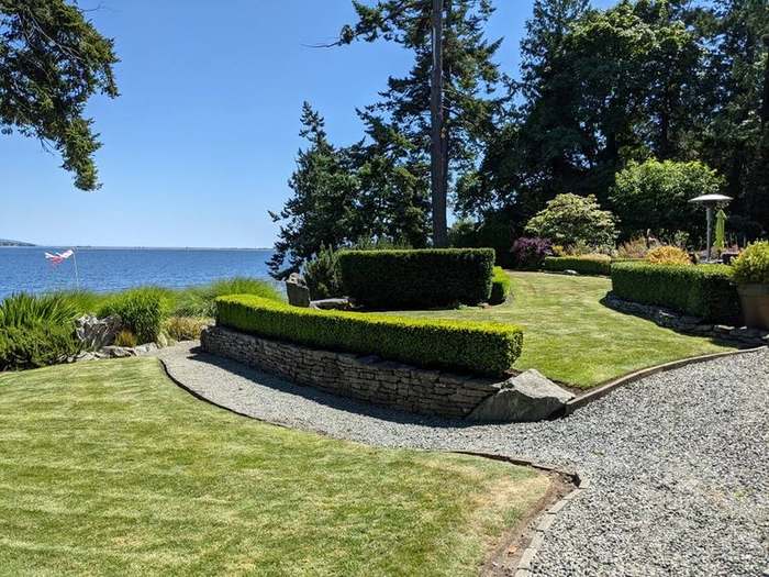 waterfront  stone walled garden lawn water