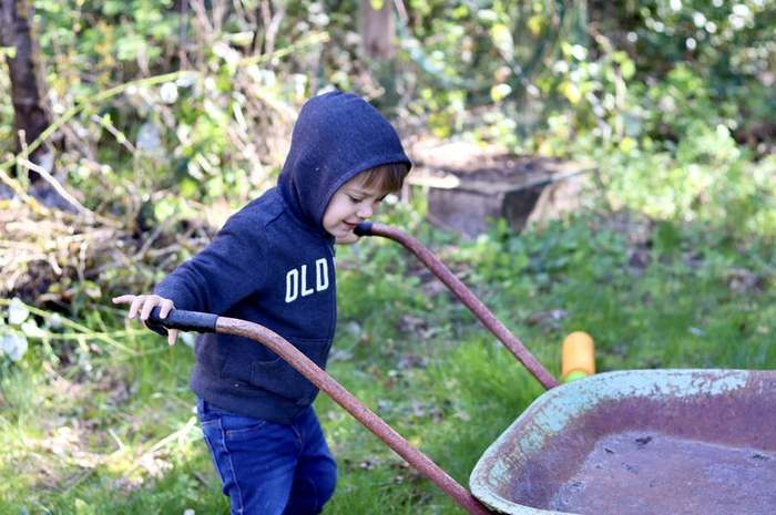 equipment  worker raking with wheelbarrow